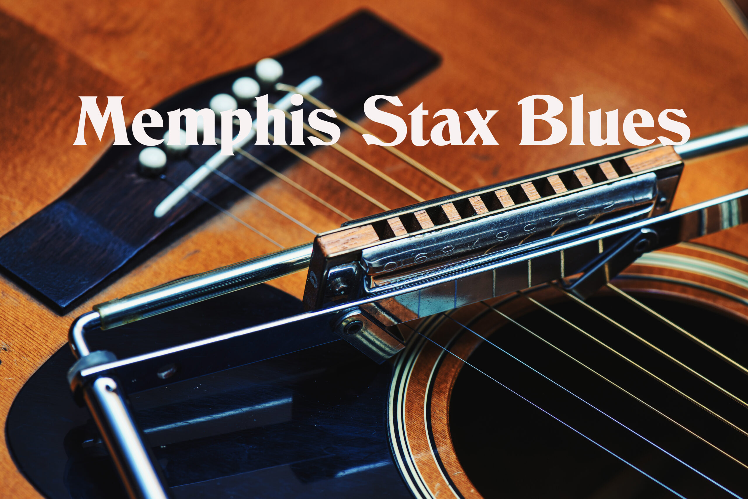 Detail of blues harmonica resting on guitar